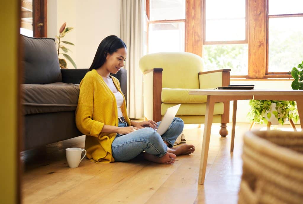 Homeowner reviewing renovation and extensions costs on her laptop with a coffee during a quiet winter morning.