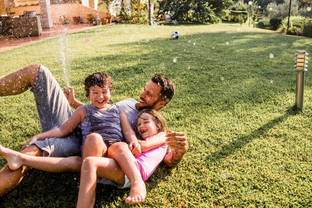 A family relaxing in their newly renovated outdoor area during spring, made possible by planning and managing renovation and extensions costs in winter.